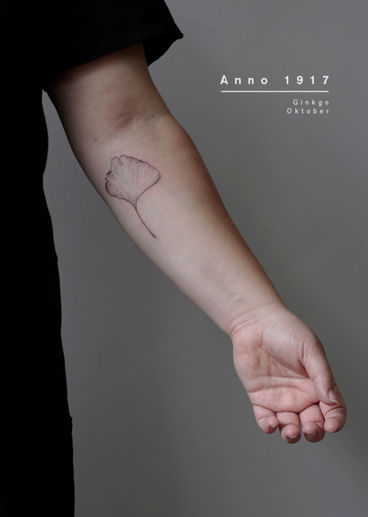 handpoke tattoo op de linker onderarm uit het anno_1917 project. De tattoo is van een gedroogd ginkgo blad. Plant informatie op de afbeelding: ginkgo, oktober
