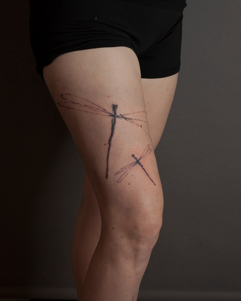 tattoo van een paar gestilleerde libelles op het rechterbovenbeen. Ongeveer 35 cm groot.