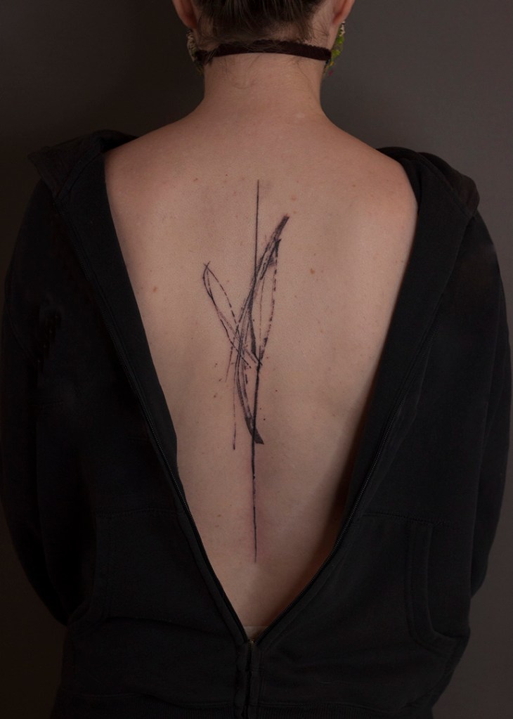handpoke tattoo op rug. Abstracte lijnen met spetters en inktstrepen