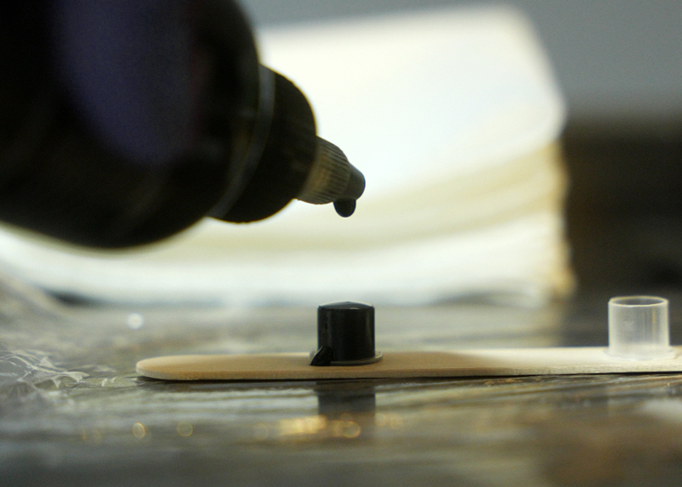 Close up van inkt die in een cupje drupt